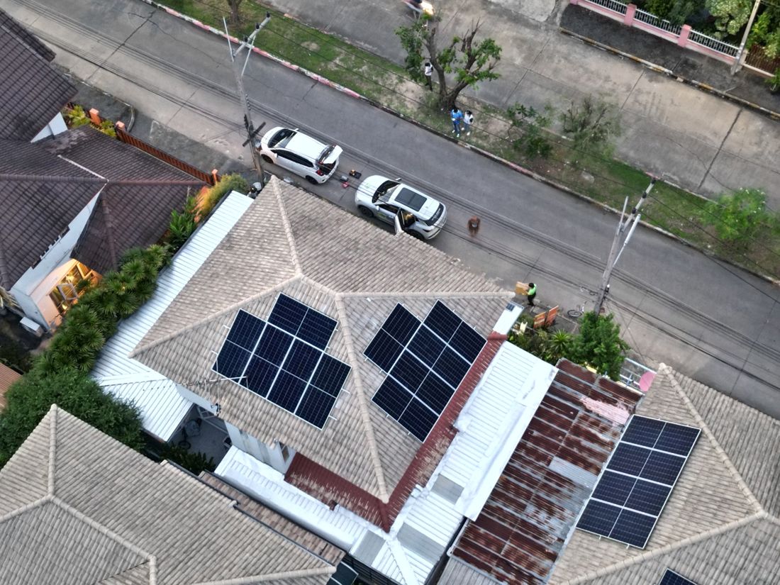 The array from above: panel groups on tiled and metal-sheet roofs
