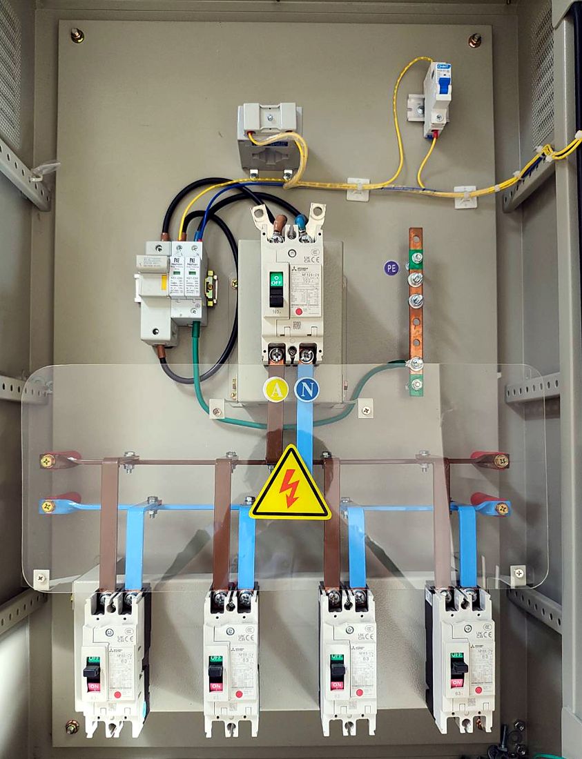 Inside the main board: main breaker, surge protector, busbars under a clear cover and four outgoing breakers